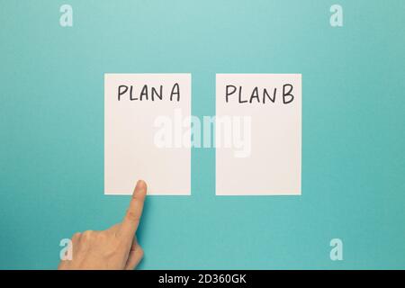 Choisissez Plan A avec le doigt sur fond bleu. Plan d'affaires, choix, changement, concept de dilemme. Vue de dessus Banque D'Images