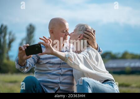 joyeux couple senior datant, prenant le selfie et s'amuser en plein air Banque D'Images