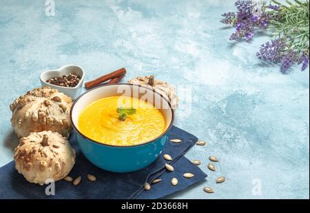 Gros plan d'une soupe à la crème de citrouille entourée de citrouilles Banque D'Images