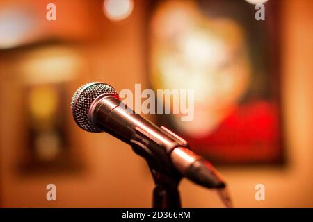 Microphone à un concert avec un arrière-plan sous forme d'images. Scène pour les artistes avec support de microphone pour l'amplification et l'enregistrement de la voix Banque D'Images