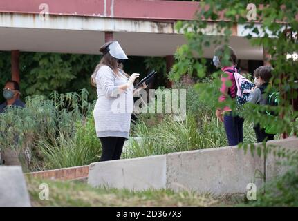 Austin, Texas USA 6 octobre 2020: L'enseignante Nicole Cormincan enregistre les élèves pour la deuxième journée de cours en personne à l'école élémentaire de Barton Hills, dans le sud d'Austin, au Texas. Toutes les températures des étudiants sont vérifiées et les revêtements de visage sont nécessaires pour entrer dans le bâtiment. Crédit : Bob Daemmrich/Alay Live News Banque D'Images