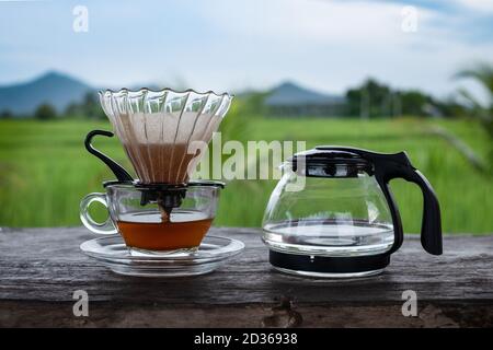 Tasse à café en verre et bouilloire sur la table en bois sur fond bleu ciel Banque D'Images