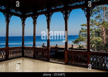 Vue sur la plage et la Baltique au printemps depuis la galerie en bois ajourée ou le belvédère en Lettonie. Plage avec sable blanc, pins et bleu mer/océan. Banque D'Images