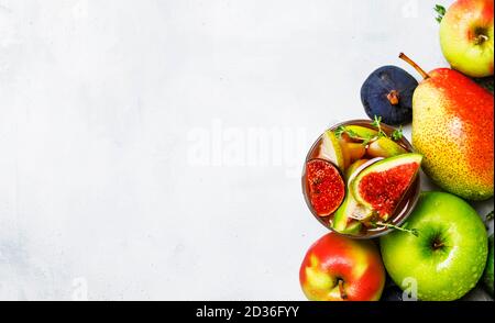 Cocktail de fruits avec vin, poires, pommes et figues, fond gris, vue sur le dessus Banque D'Images