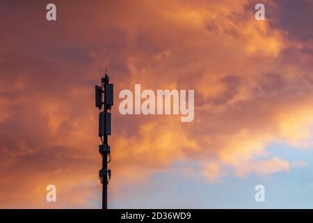 Tour de communications cellulaires sur de beaux nuages spectaculaires arrière-plan en soirée, espace de copie Banque D'Images