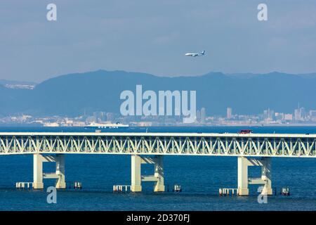 Osaka / Japon - 16 novembre 2017 : avion D'ANA survolant le pont Sky Gate, atterrissant à l'aéroport international de Kansai, avec la ville de Kobe visib Banque D'Images