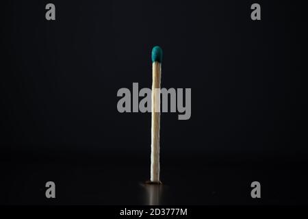Bâton d'allumette brûlé isolé sur fond noir. Banque D'Images