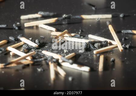 Utilisé allumettes en bois avec les restes de cendres sur un tableau noir. Mise au point sélective. Contraste élevé. Banque D'Images