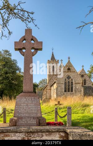 Mémorial de guerre et église dans le petit village de Ringstead à Norfolk. Banque D'Images