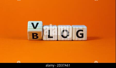 Blog ou Vlog. Transformé un cube et changé l'expression 'BLOG' en 'VLOG' ou vice versa. Magnifique arrière-plan orange. Concept d'entreprise et d'information. Banque D'Images