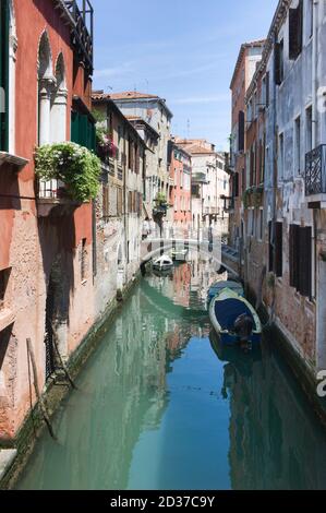 Étroit canal de Venise avec des bateaux par jour ensoleillé. Paysage urbain traditionnel de Venise. Image verticale Banque D'Images