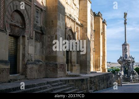Rue de Cordoue pavée d'une statue à la fin et un très vieux mur en pierre Banque D'Images