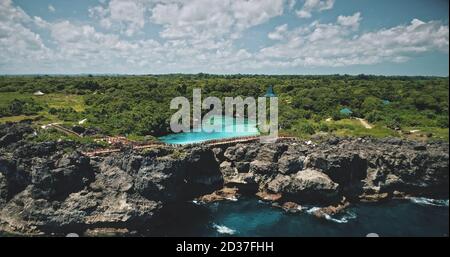 Falaise océan côte avec lac limpid sur le green top vue aérienne. Paysage indonésien pittoresque à la végétation tropicale nature de la lagune de Weburi, île de Sumba. Un paysage d'été cinématographique en douceur Banque D'Images