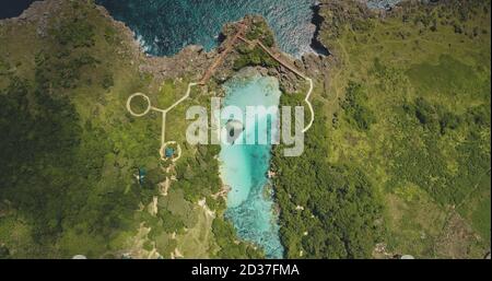 En haut du chemin conçu au lac azur sur la falaise verte, vue aérienne sur la rive de la mer. Verdure prairie tropicale avec arbres, herbes sur la côte de l'océan. Paysage épique de Weburi, île de Sumba, Indonésie Banque D'Images