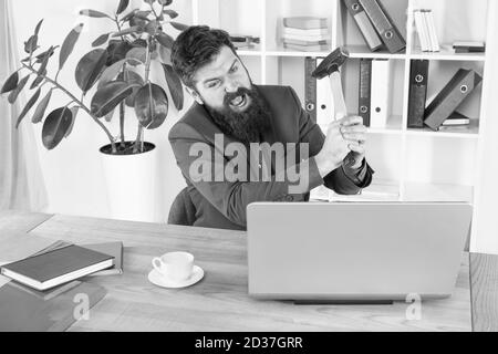 Crier. Résoudre certains problèmes d'affaires. Ordinateur est à la traîne. Homme d'affaires ou Manager en colère avec un marteau à traîner. Homme d'affaires agressif au bureau. Raisons du retard de l'ordinateur. Routine de bureau de haine. Banque D'Images