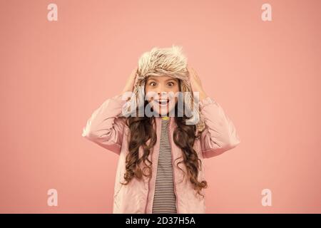 Vacances d'hiver. L'activité de la petite enfance. des vêtements chauds pour la saison froide. surpris enfant toile rose fashion kid.. trendy girl ressemblent à de la fourrure. hipster earflap hat accessoire. petite fille winter hat. Banque D'Images