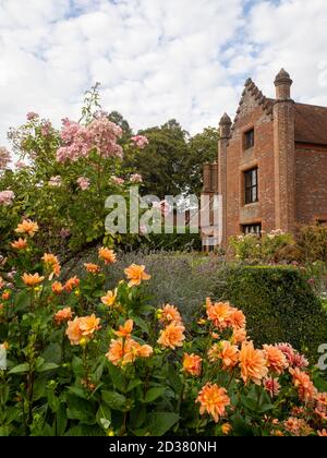 Chenies Manor Gardens en septembre. Chenies Manor encadré de rose pastel Ballerina et de Dahlia 'r Frans' couleur pêche dorée par beau temps. Banque D'Images