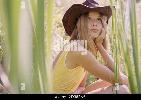 Gros plan de la femme hippie en maillot de bain et chapeau de cow-boy roseaux au coucher du soleil Banque D'Images