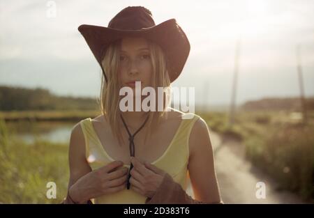 Gros plan hippie femme en maillot de bain et chapeau de cow-boy sur un route de terre Banque D'Images