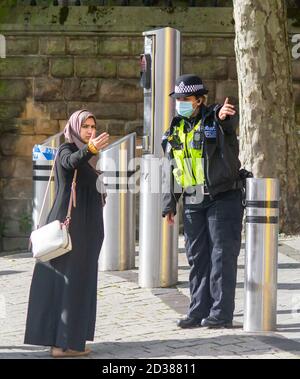 Une femme agent de police des West Midlands donne des indications à une dame autour d'un cordon de police suite à une agression de nuit contre le Marchés de Birmingham Banque D'Images