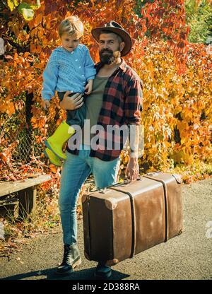 Un papa barbu parle de voyage à son fils. Voyageur avec beaucoup d'expérience. Esprit d'aventurisme. Père avec valise et son fils. Temps en famille Banque D'Images