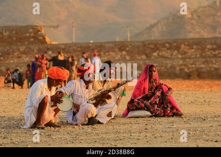 Un groupe de personnes assis sur le terrain et jouant des instruments de musique traditionnels indiens à Pushkar, Rajasthan, Inde, le 19 novembre 2018 Banque D'Images