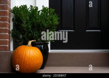 Porte d'entrée décorée de Thanksgiving avec potiron et plante en pot. Saison d'automne. Banque D'Images