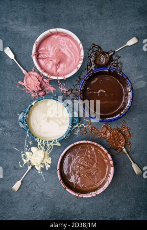 Quatre types de chocolat fondu dans des bols. Chocolat noir, chocolat au lait, chocolat blanc et chocolat rubis Banque D'Images