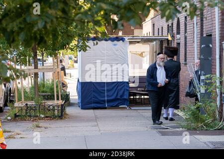 NEW YORK, NY - 07 OCTOBRE 2020 : des juifs orthodoxes ne portant pas de masques vus près de Sukkah dans le quartier de Borough Park à Brooklyn. Banque D'Images
