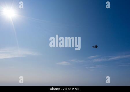 petite silhouette d'avion en vol sur fond de ciel bleu clair. photo aérienne Banque D'Images