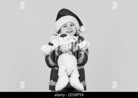 Nouvelle année, nouveaux objectifs. petite fille santa claus hat fond rouge. Se préparer à la célébration du nouvel an de vacances de Noël.. l'hiver saison joyeux Noël. shopping vente. petit père avec jouet. Banque D'Images