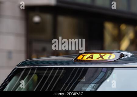 Un taxi noir de Londres signe avec image - un arrière-plan Banque D'Images