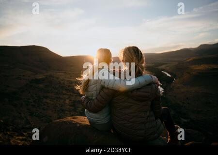Mère et fille appréciant la vue après une randonnée en montagne au coucher du soleil Banque D'Images