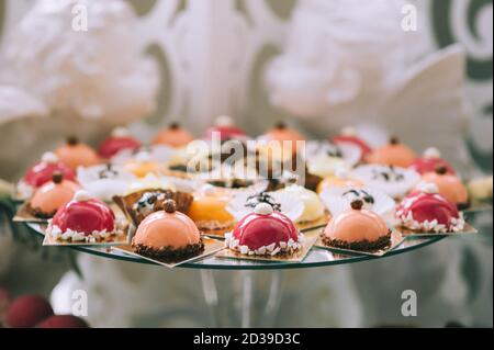 Plusieurs délicieuses friandises colorées sur la table dans une barre de bonbons lors d'un mariage. Délicieux bonbons sur buffet de bonbons de mariage avec desserts, petits gâteaux. Onglet Sweet Banque D'Images