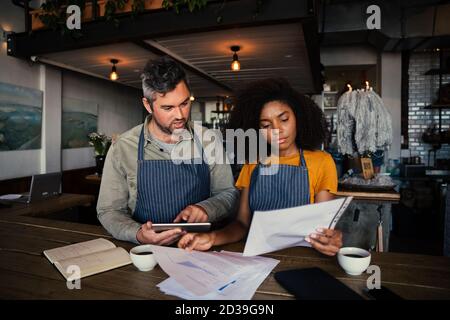 Un collègue homme et femme inquiet qui regarde les finances dans un café authentique. Banque D'Images