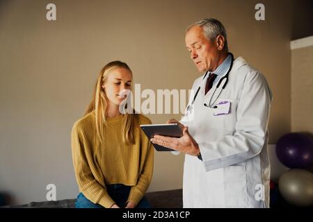 Un médecin du pelage discute des résultats avec une patiente exercez-vous Banque D'Images