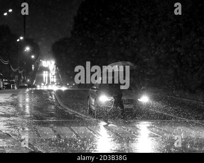 Moscou. Russie. 17 septembre 2020 passage piéton dans la ville la nuit pendant une grosse averse. Silhouette d'un homme avec un parapluie dans la lumière Banque D'Images