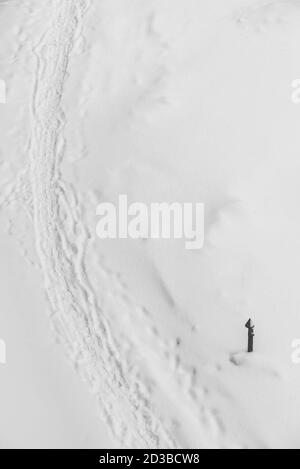 Traces de chaussures sur neige blanche. Piste de bottes sur chasse-neige. Fond d'hiver texturé de sentier enneigé. Cave enneigée avec espace de photocopie. Abstrac Banque D'Images