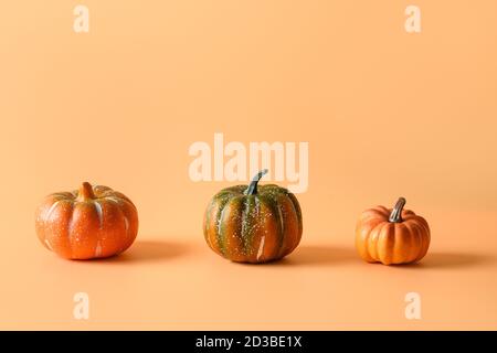 Jour de Thanksgiving ou Halloween trois citrouilles différentes sur fond orange. Espace pour le texte ou la conception. Banque D'Images