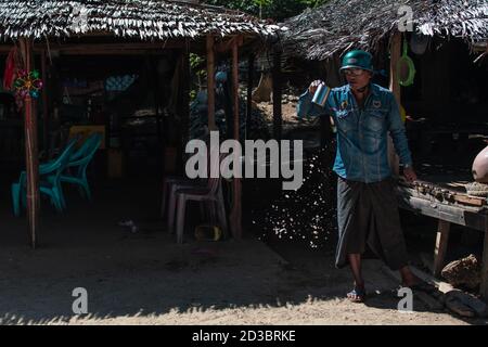 Ngwesaung, Myanmar - 26 décembre 2019 : un homme du myanmar crache sa boisson sur le sol après avoir étanché sa soif Banque D'Images