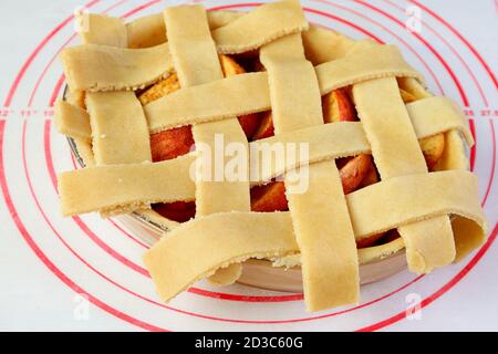 Pâte tissée sur la plaque à tarte pour la croûte de treillis d'une tarte aux pommes maison Banque D'Images