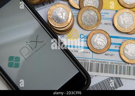 Florianopolis, Brésil. 07/10/2020: Gros plan du logo PIX sur l'écran du smartphone et pièces de monnaie sur les factures et les factures à payer avec code-barres. PIX est la nouvelle Centra Banque D'Images