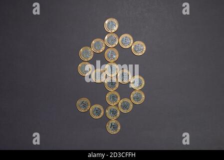 Signe dollar fait par des pièces de monnaie argentées brillantes avec des bords dorés sur fond noir. Concept argent et finance. Symbole de devise. Banque D'Images