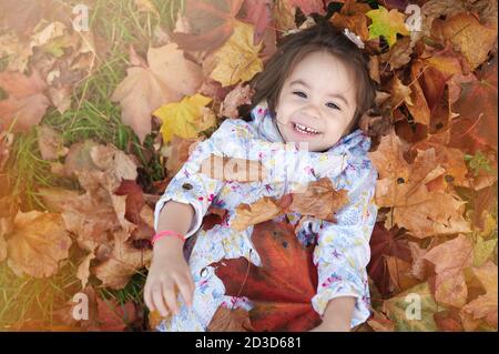 Joyeux enfant souriant dans un fond naturel au-dessus de la vue de dessus Banque D'Images