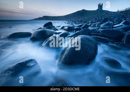 Château de Dunstanburgh depuis la baie d'Embleton, Embleton, Northumberland peu avant le lever du soleil. Printemps (avril 2019) Banque D'Images