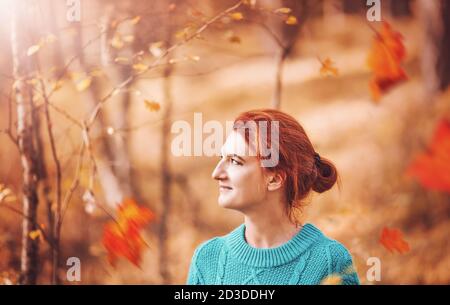 Jolie femme aux cheveux rouges dans la forêt d'automne. Banque D'Images