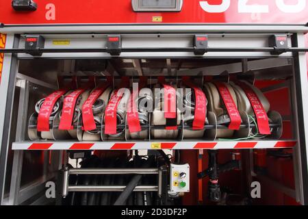 Cracovie. Cracovie. Pologne. Tuyaux en toile avec raccords métalliques roulés dans le compartiment de rangement du camion d'incendie. Banque D'Images