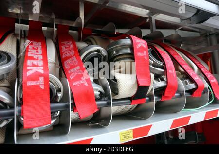 Cracovie. Cracovie. Pologne. Tuyaux en toile avec raccords métalliques roulés dans le compartiment de rangement du camion d'incendie. Banque D'Images