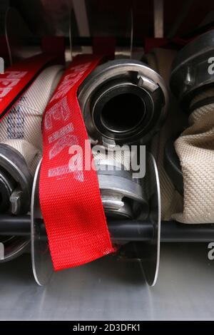 Cracovie. Cracovie. Pologne. Tuyaux en toile avec raccords métalliques roulés dans le compartiment de rangement du camion d'incendie. Banque D'Images