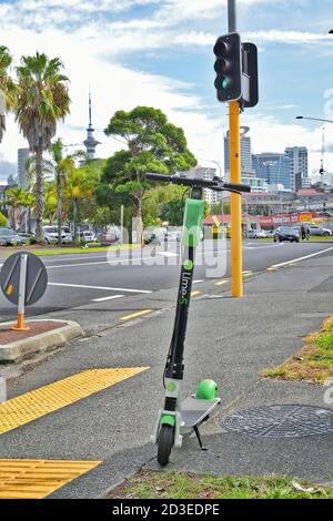 AUCKLAND, NOUVELLE-ZÉLANDE - 05 avril 2019 : Auckland / Nouvelle-Zélande - 5 2019 avril : scooter électrique à la chaux stationné au Strand avec vue sur la ville d'Auckland Banque D'Images